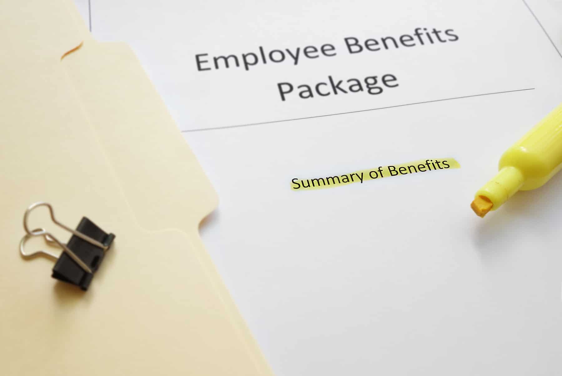 Close-up of an 'Employee Benefits Package' document with 'Summary of Benefits' highlighted in yellow, plus a yellow highlighter and binder clip in view.